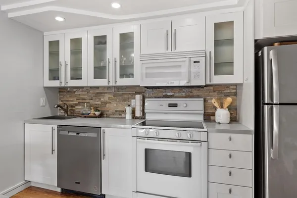 a kitchen with stainless steel appliances granite countertop a stove and a refrigerator