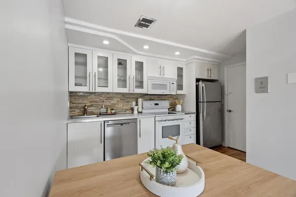 a kitchen with stainless steel appliances granite countertop a refrigerator a stove and a sink