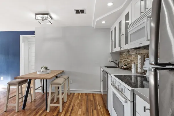 a living room with furniture rug and kitchen view