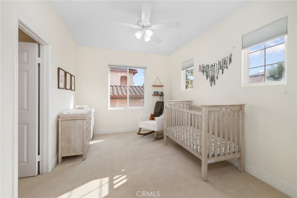45644 Camino Rubi Temecula, CA 92592 - Photo 28 of 51 a bedroom with a baby bed a couch and a window