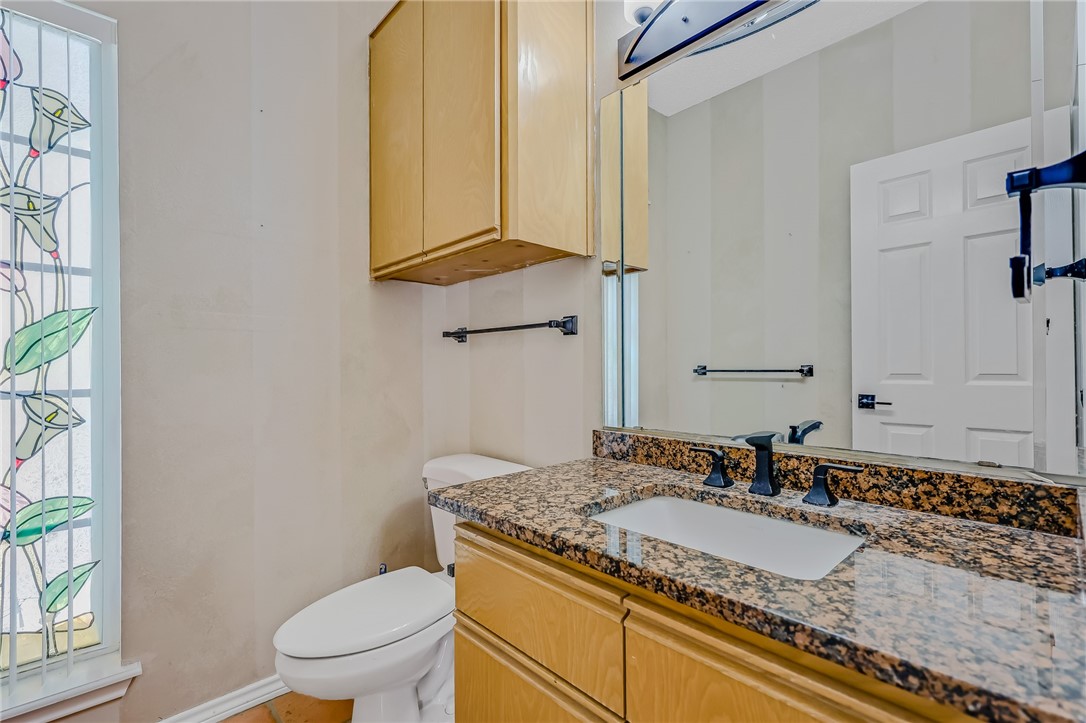 5917 Harvest Hill Road Corpus Christi, TX 78414 - Photo 15 of 40 a bathroom with a granite countertop sink toilet and mirror