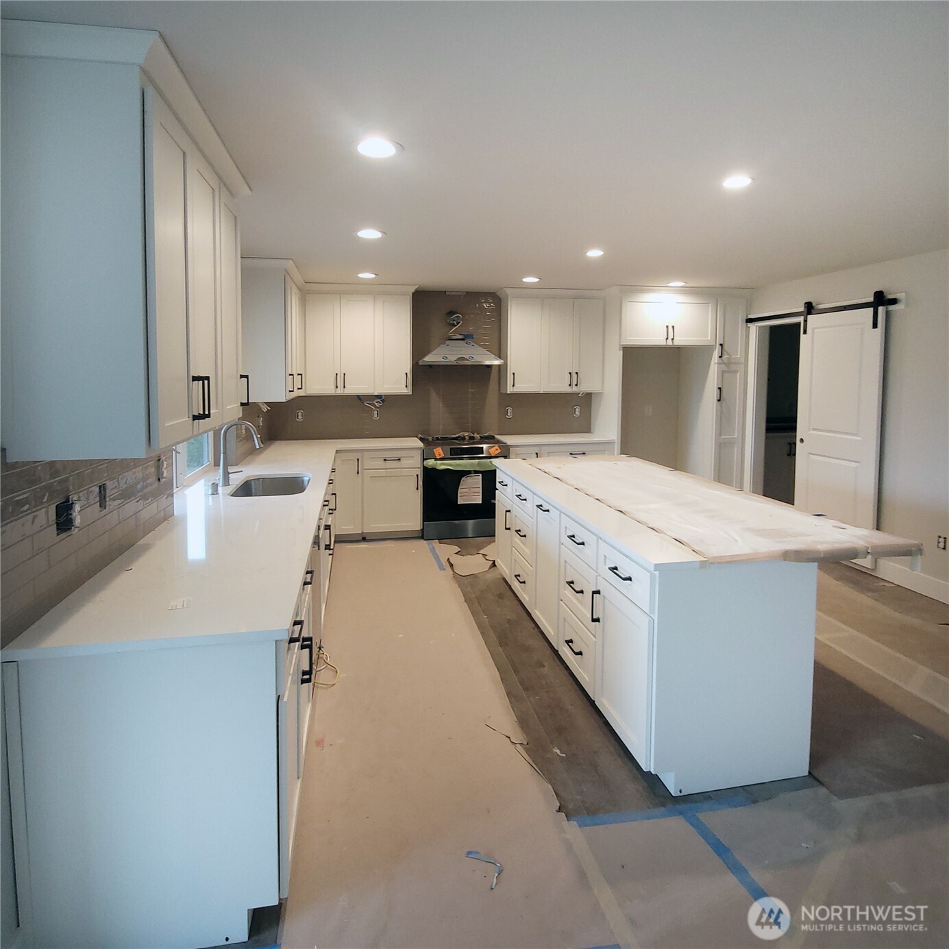 320 East 4th Street Union, WA 98592 - Photo 5 of 35 a large kitchen with kitchen island a sink a stove a refrigerator and a dining table with wooden floor