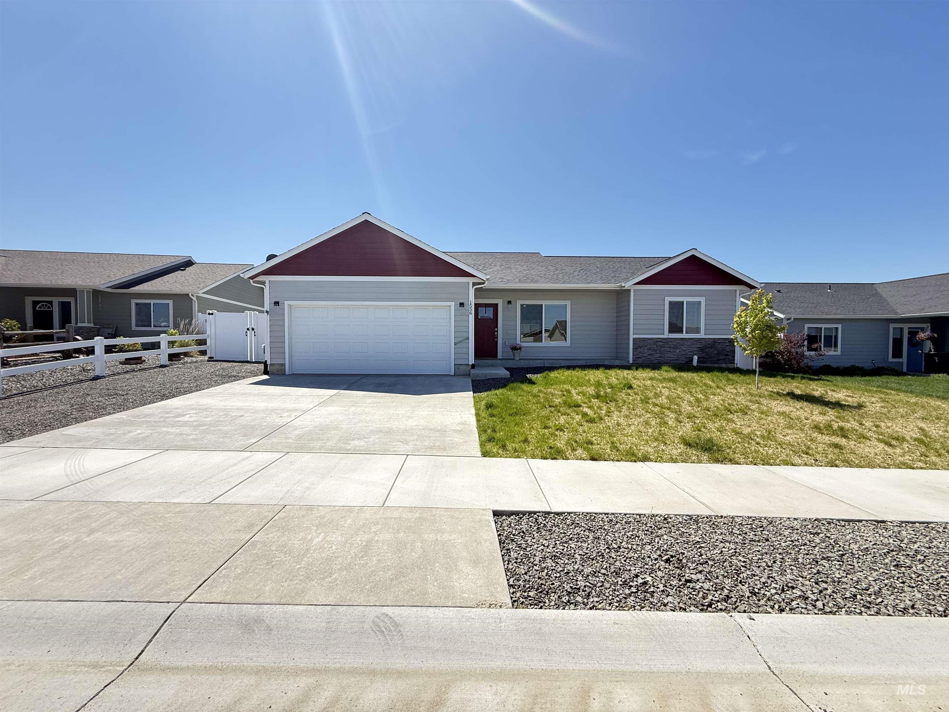 1556 Frontier Drive Lewiston, ID 83501 - Photo 1 of 23 Ranch-style residence featuring a prominent two-car garage, red gable accents, light gray siding, and a concrete driveway
