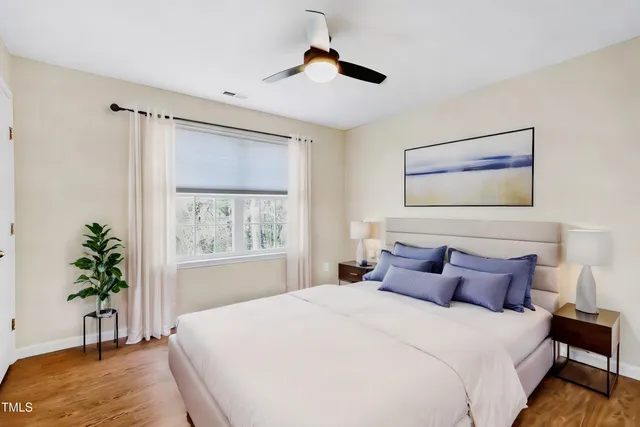 a bedroom with a large bed and a chandelier