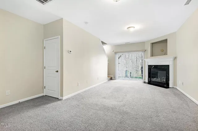 a view of empty room with a fireplace