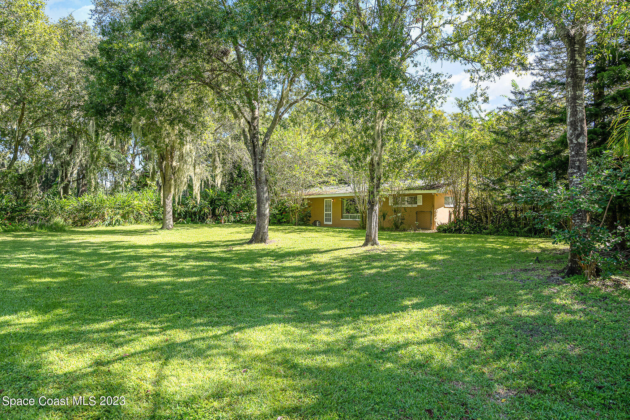 3395 Turtle Mound Road Melbourne, FL 32934 - Photo 2 of 48 a view of a house with a big yard and large trees