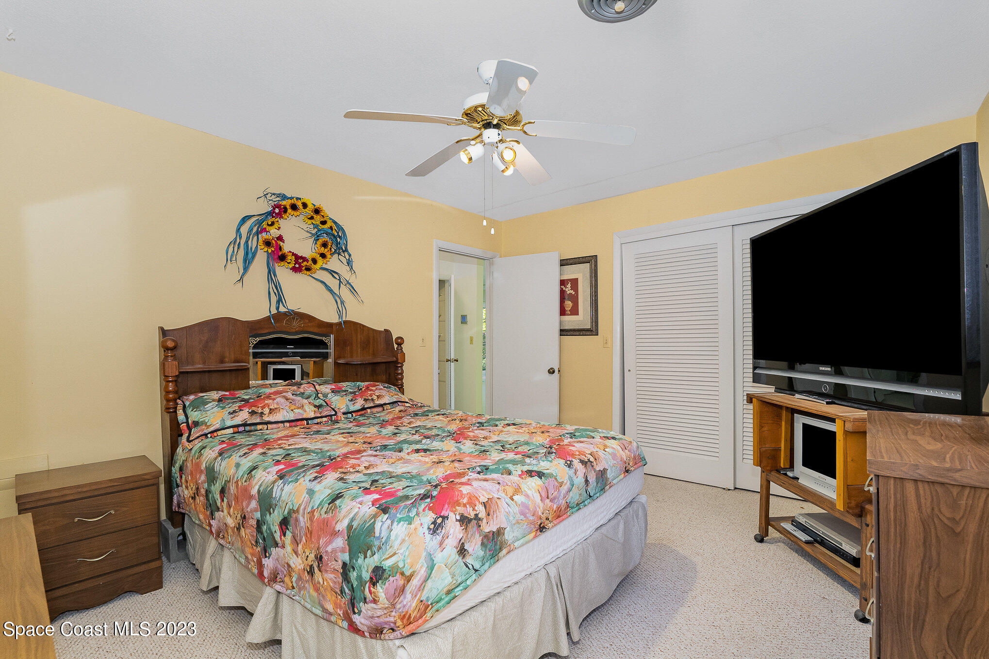 3395 Turtle Mound Road Melbourne, FL 32934 - Photo 23 of 48 a bedroom with a bed and a flat screen tv