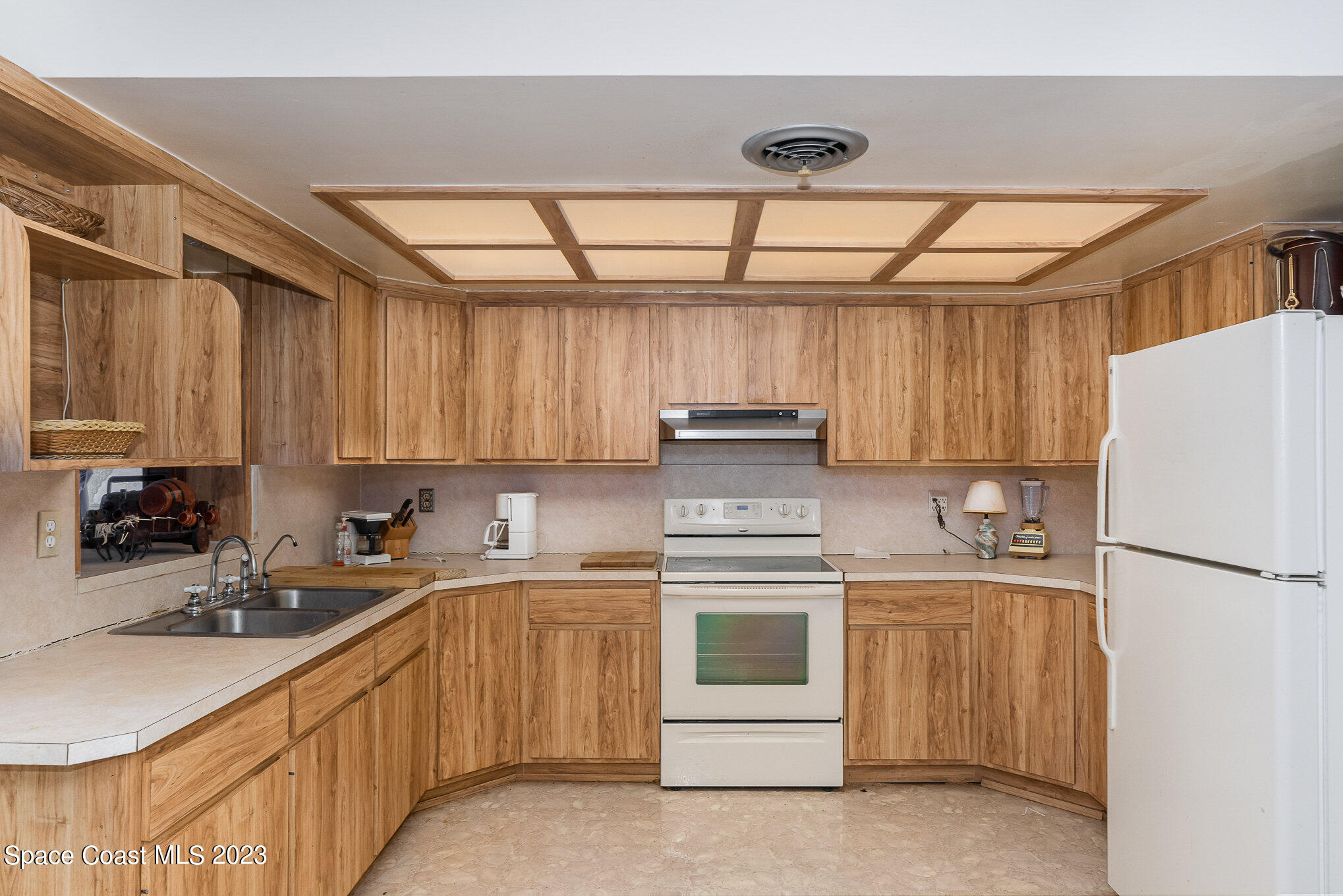 3395 Turtle Mound Road Melbourne, FL 32934 - Photo 27 of 48 a kitchen with a sink a refrigerator and cabinets