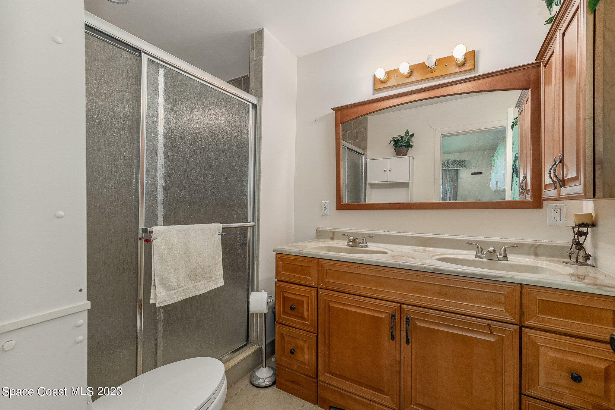 3395 Turtle Mound Road Melbourne, FL 32934 - Photo 30 of 48 a bathroom with a toilet sink and mirror