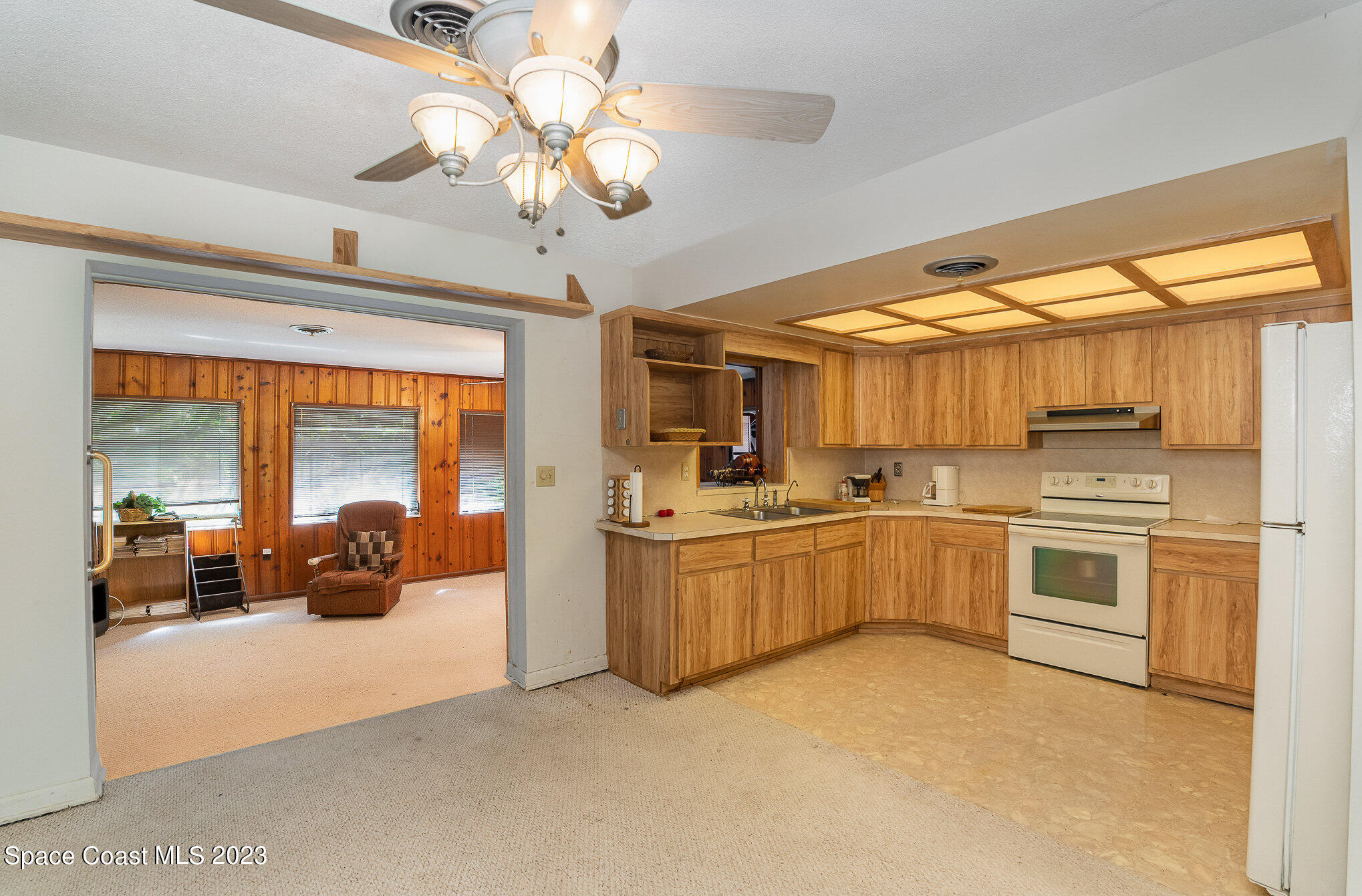 3395 Turtle Mound Road Melbourne, FL 32934 - Photo 33 of 48 a large white kitchen with stainless steel appliances granite countertop a lot of counter space and a view of living room