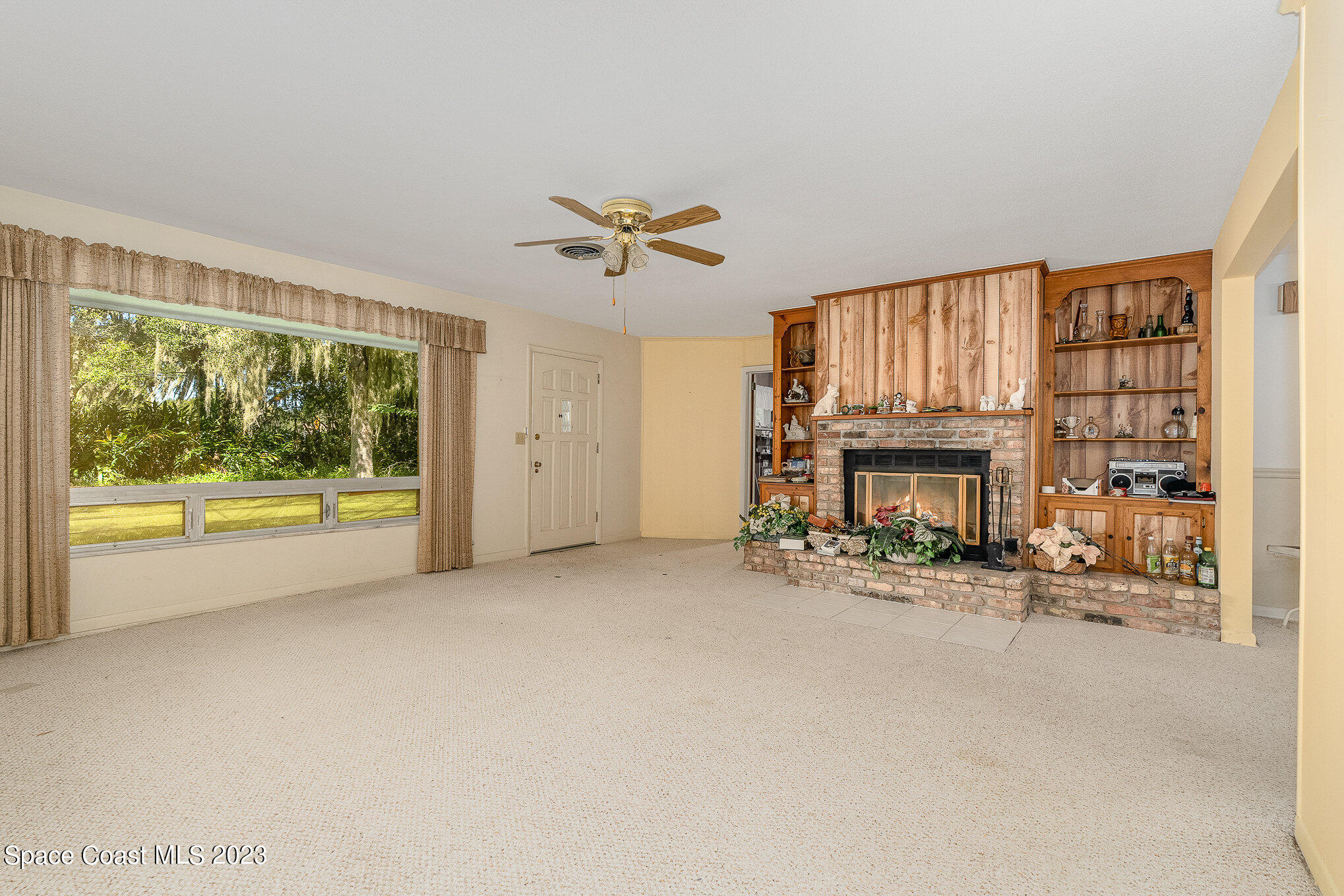 3395 Turtle Mound Road Melbourne, FL 32934 - Photo 4 of 48 a view of an empty room with fireplace and a window