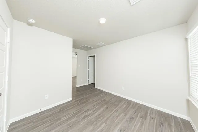 a view of an empty room with wooden floor