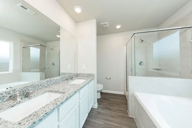 a spacious bathroom with a granite countertop tub sink and shower