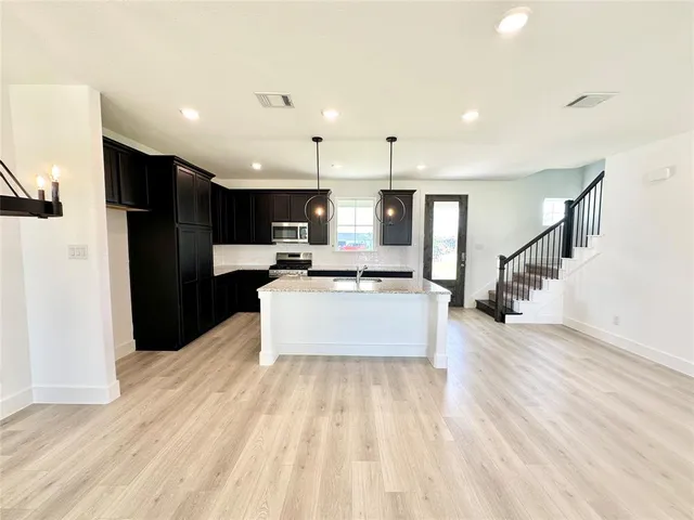 a large kitchen with a large counter top appliances and cabinets