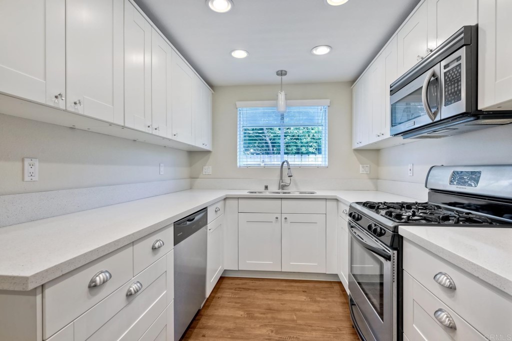 2425-27 Torrejon Place Carlsbad, CA 92009 - Photo 11 of 59 a kitchen with stainless steel appliances granite countertop a stove sink and cabinets