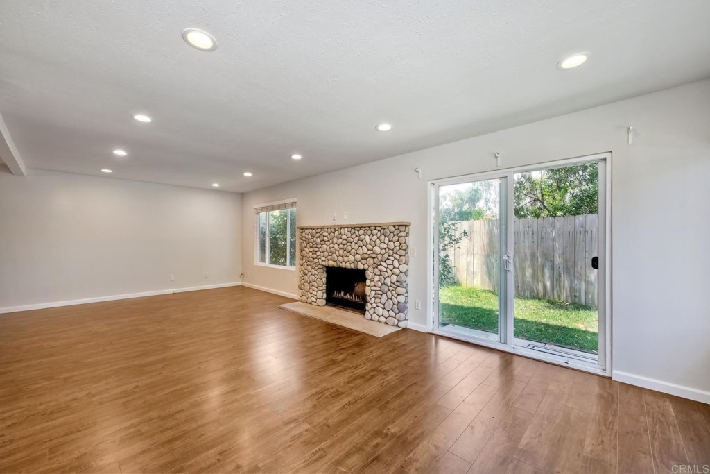 2425-27 Torrejon Place Carlsbad, CA 92009 - Photo 5 of 59 an empty room with wooden floor fireplace and windows