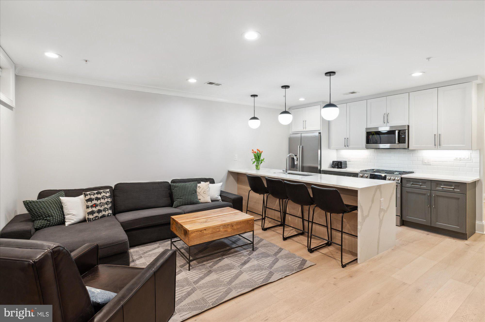 2150 Florida Avenue Northwest, Unit 1 Washington, DC 20008 - Photo 2 of 23 a living room with stainless steel appliances kitchen island granite countertop a couch and cabinets