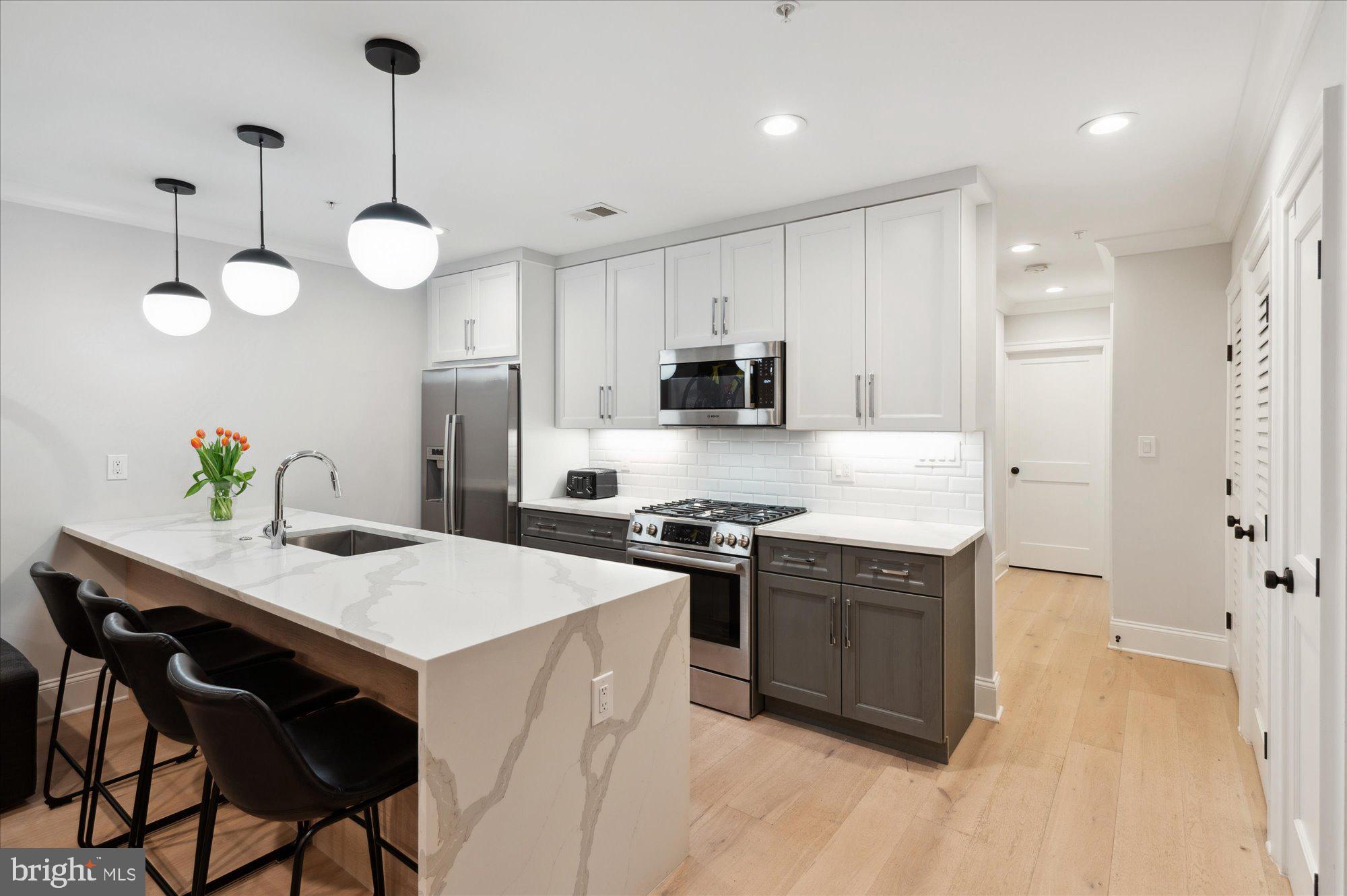 2150 Florida Avenue Northwest, Unit 1 Washington, DC 20008 - Photo 5 of 23 a kitchen with stainless steel appliances a stove center island refrigerator and cabinets
