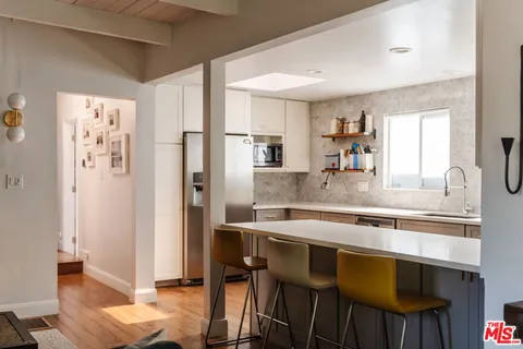 a kitchen with stainless steel appliances granite countertop a stove a refrigerator and a dining table