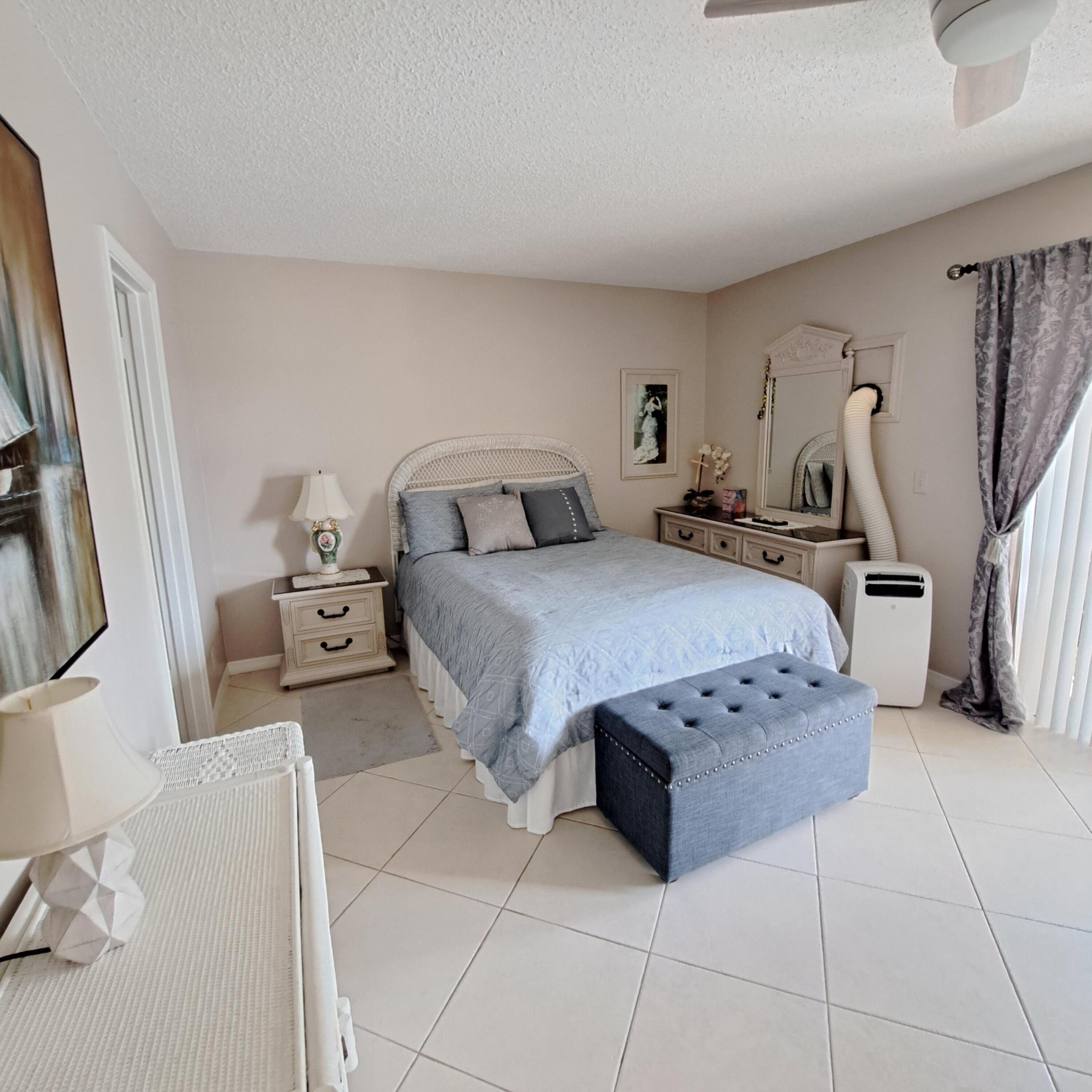 53 Northampton C West Palm Beach, FL 33417 - Photo 15 of 27 a bedroom with a bed a couch and dresser