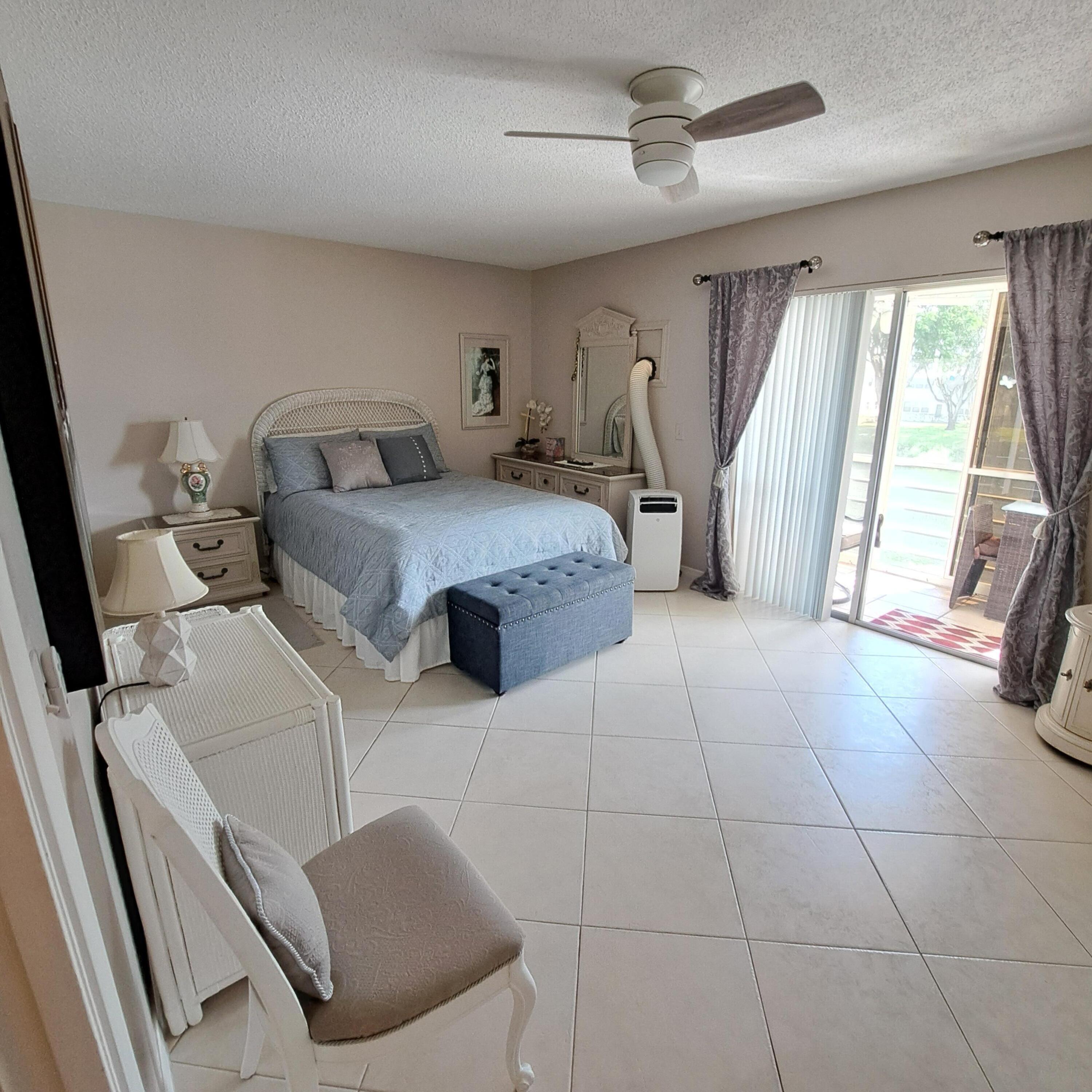 53 Northampton C West Palm Beach, FL 33417 - Photo 16 of 27 a bedroom with a bed and a large window