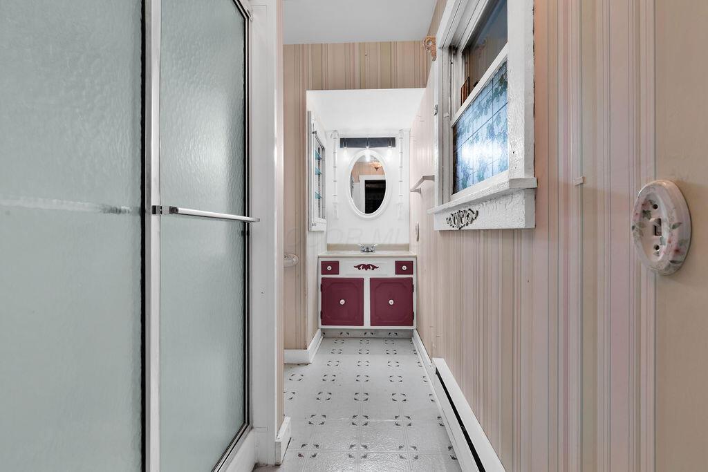 4409 Newton Road Northeast Newark, OH 43055 - Photo 45 of 87 • Neutral vinyl flooring • Papered walls • Shower stall with glass door • Ceiling light • Ceiling exhaust • Enclosed vanity with single bowl, cultured marble sinktop