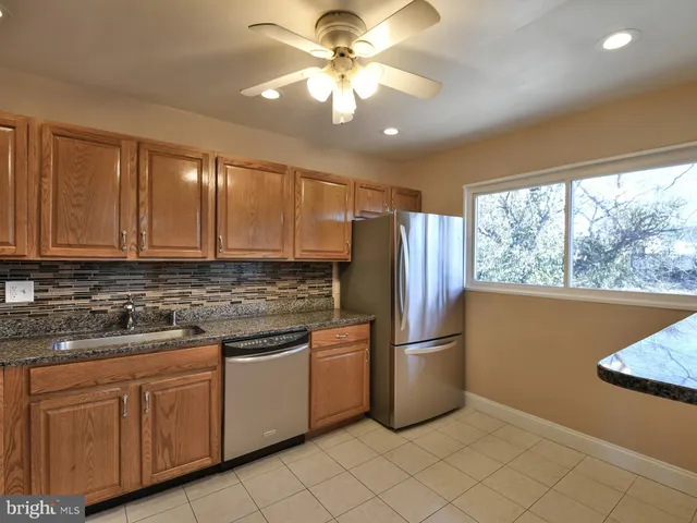 a kitchen with stainless steel appliances granite countertop a sink and cabinets