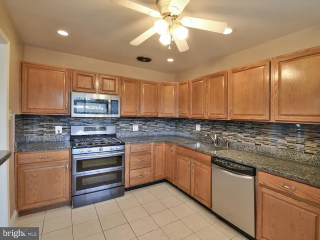 a kitchen with stainless steel appliances granite countertop a sink and a stove