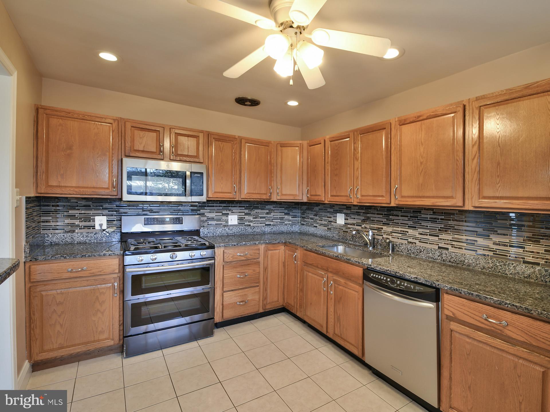 2308 Senator Avenue District Heights, MD 20747 - Photo 21 of 66 a kitchen with stainless steel appliances granite countertop a stove sink and cabinets