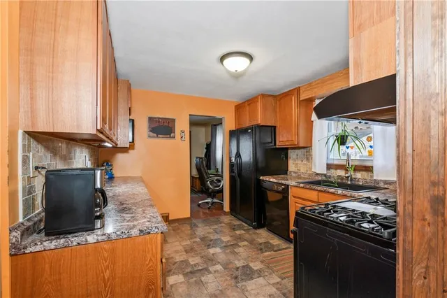 a kitchen with stainless steel appliances granite countertop a refrigerator a stove and a sink with wooden floor