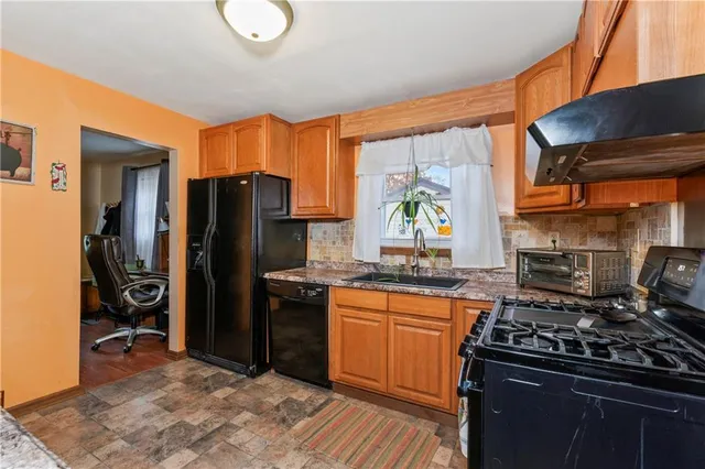 a kitchen with stainless steel appliances granite countertop a stove a refrigerator and a sink