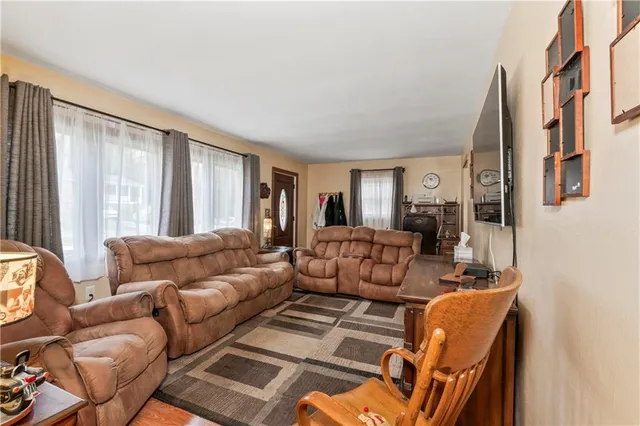 a living room with furniture fireplace and a large window