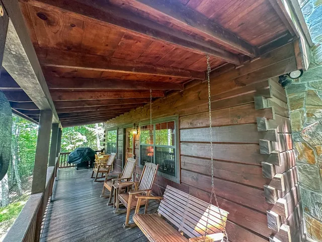 a view of a roof deck with wooden fence and a bench