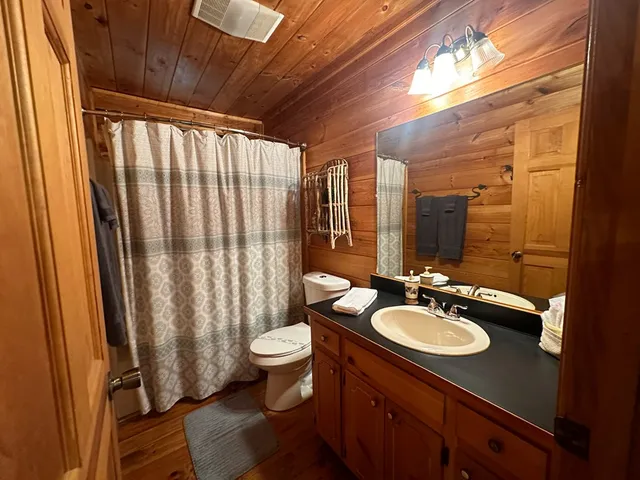 a kitchen with granite countertop a refrigerator a sink dishwasher a stove and white cabinets with wooden floor