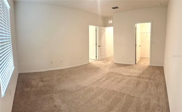 an empty room with closet and windows