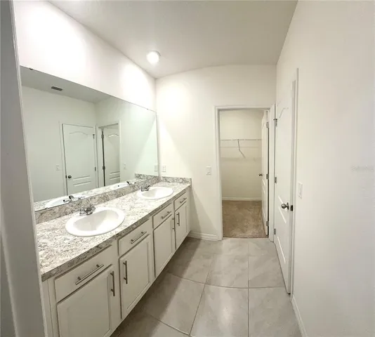 a spacious bathroom with a granite countertop sink a mirror and a