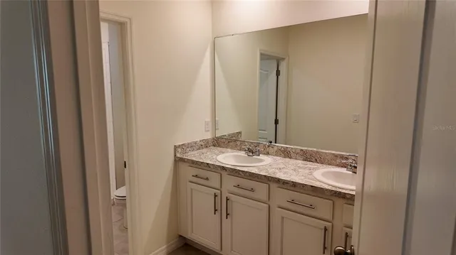 a bathroom with a granite countertop sink and a mirror