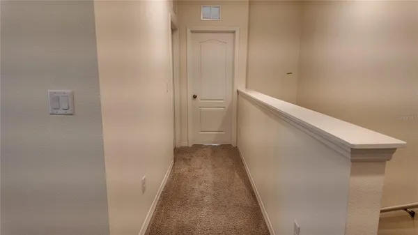 a view of a hallway with wooden floor and closet