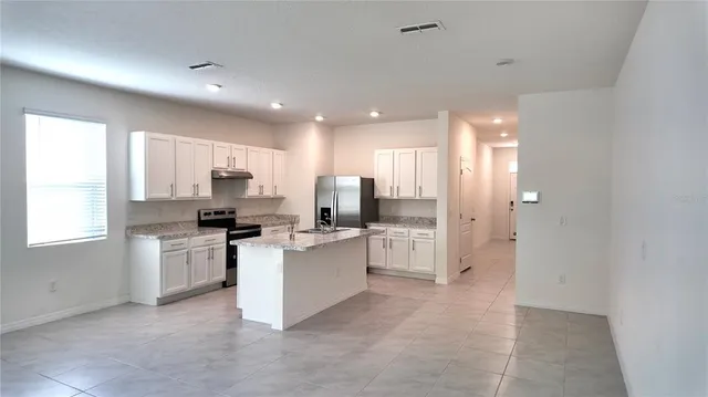a kitchen with white cabinets and stainless steel appliances