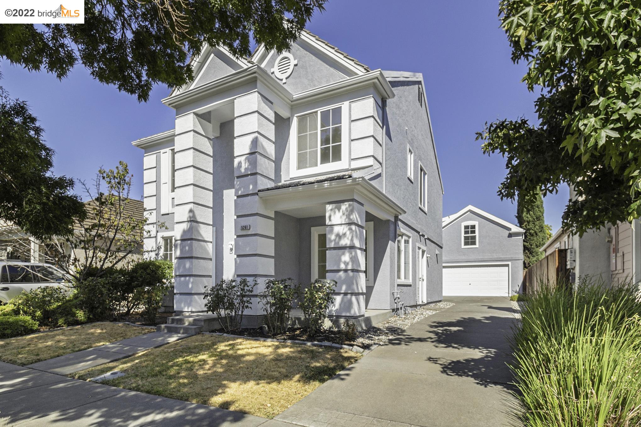a view of a brick house with a large windows and a flower garden