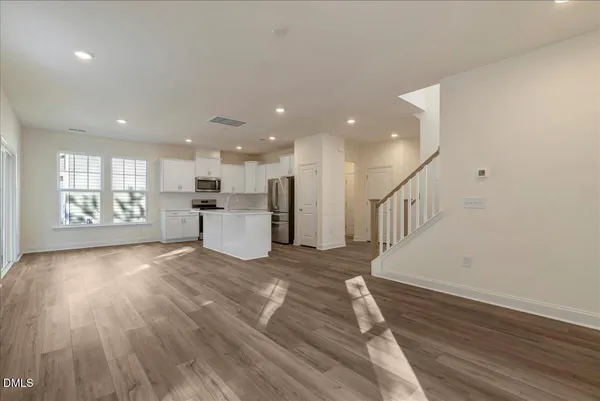 a view of a kitchen with a white kitchen appliances wooden floor and a window