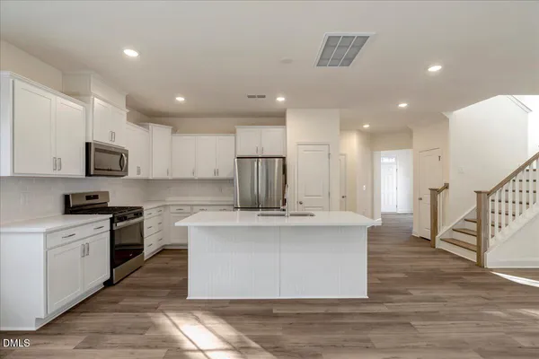 a view of kitchen with kitchen island sink stainless steel appliances and cabinets