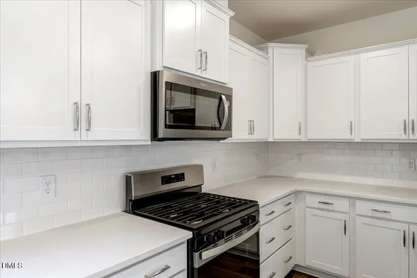 a kitchen with cabinets appliances and a window
