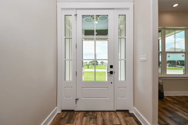 a view of a hallway with wooden floor and a window