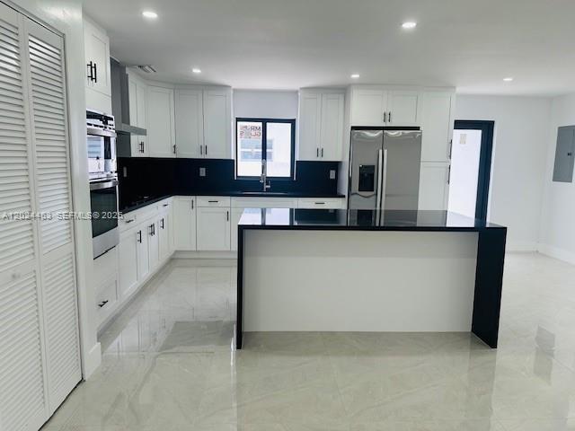 11870 Southwest 5th Street, Unit 1 Miami, FL 33184 - Photo 6 of 38 a large kitchen with stainless steel appliances a refrigerator and a stove top oven