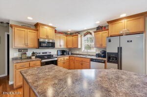 338 Pistole Road Sparta, TN 38583 - Photo 9 of 39 a kitchen with stainless steel appliances granite countertop a stove top oven a sink dishwasher a refrigerator and cabinets with wooden floor