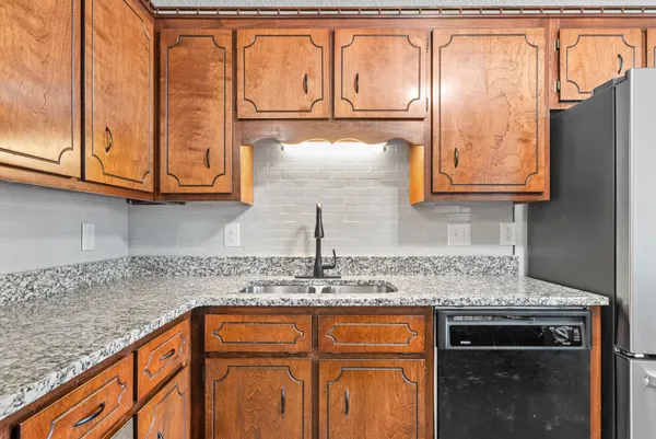 a kitchen with stainless steel appliances granite countertop a sink and cabinets
