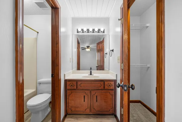 a bathroom with a granite countertop sink a toilet and a mirror