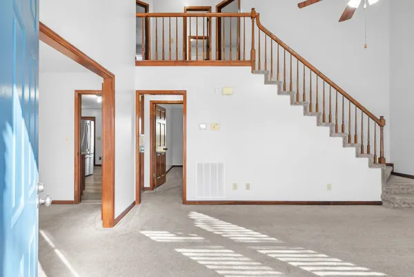 a view of a hallway with wooden floor and staircase