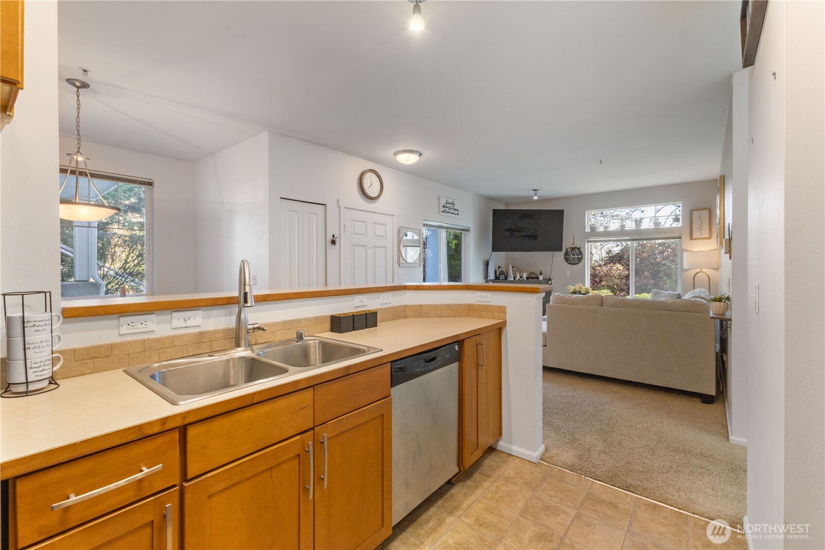 21430 40th Place South, Unit A Seattle, WA 98198 - Photo 11 of 27 a view of a kitchen with a sink and a dishwasher with a large mirror